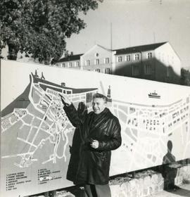 Józef Piotrowski stojący pod mapą turystyczną Kołobrzegu