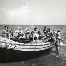 Grupa kobiet obok drewnianej łodzi rybackiej