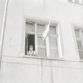 Kobieta z flagą Polski w oknie