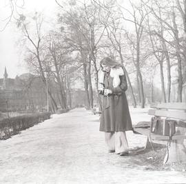 Kobieta z aparatem fotograficznym podczas zimowego spaceru w Parku Mikołaja Kopernika